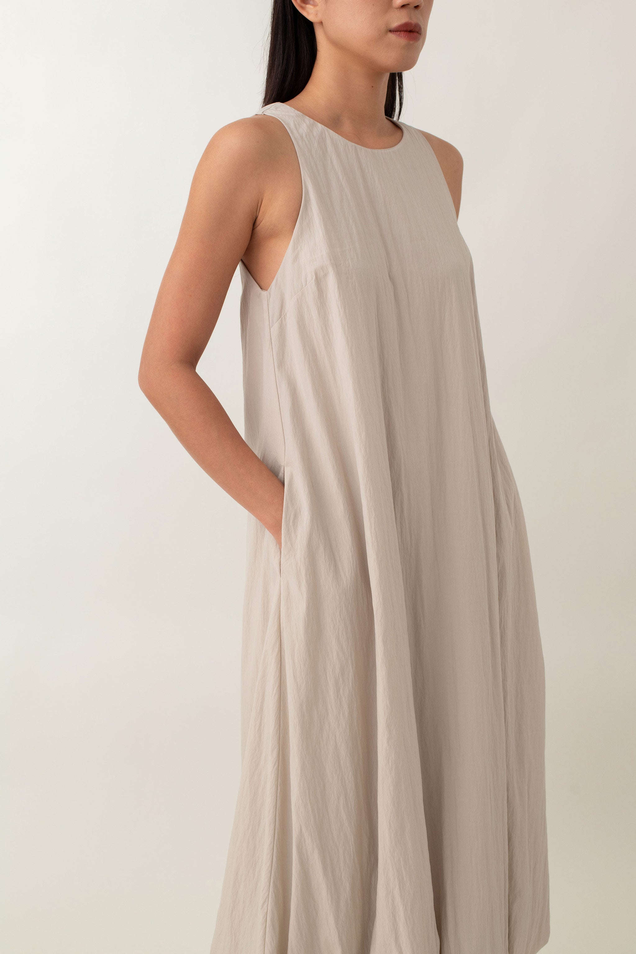 With its airy balloon silhouette that tapers gently at the hem, the Saffron Dress offers a playful and relaxed vibe. The dress has a simple sleeveless design with a round neckline and handy side pockets, perfect for stashing your essentials. The back zipper makes it easy to slip on and off, adding to its effortless appeal.