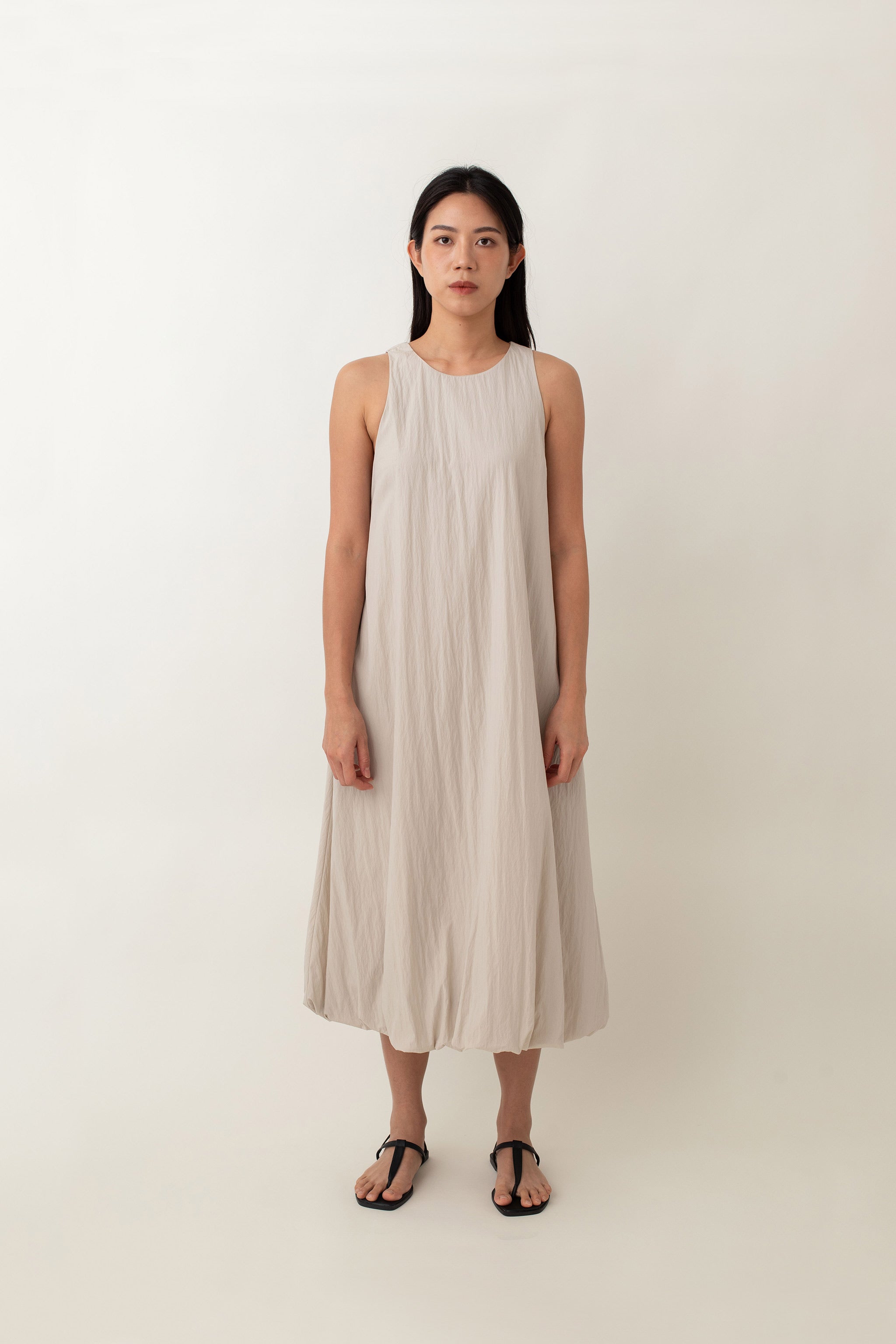 With its airy balloon silhouette that tapers gently at the hem, the Saffron Dress offers a playful and relaxed vibe. The dress has a simple sleeveless design with a round neckline and handy side pockets, perfect for stashing your essentials. The back zipper makes it easy to slip on and off, adding to its effortless appeal.